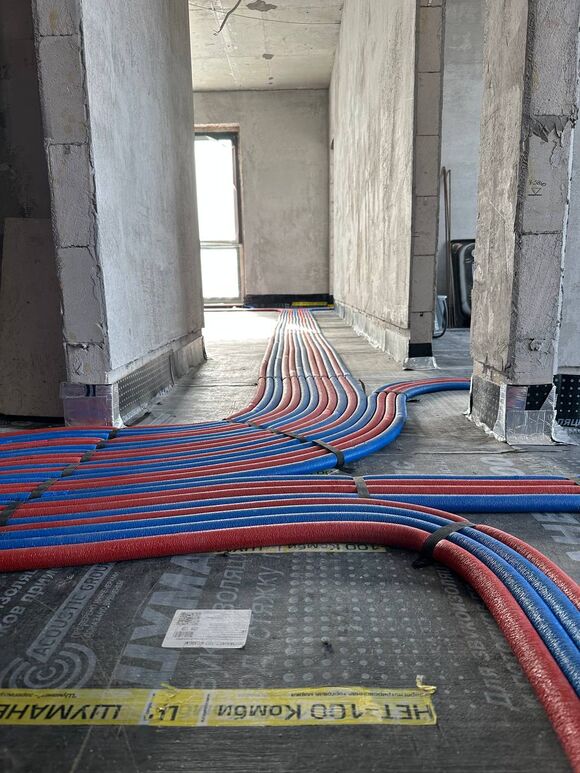 Коллекторно-лучевая разводка труб отопления. Защита специальным трубным утеплителем (термоизоляцией) синего и красного цветов, что помогает различать «подачу» и «обратку», а также снижает теплопотери.