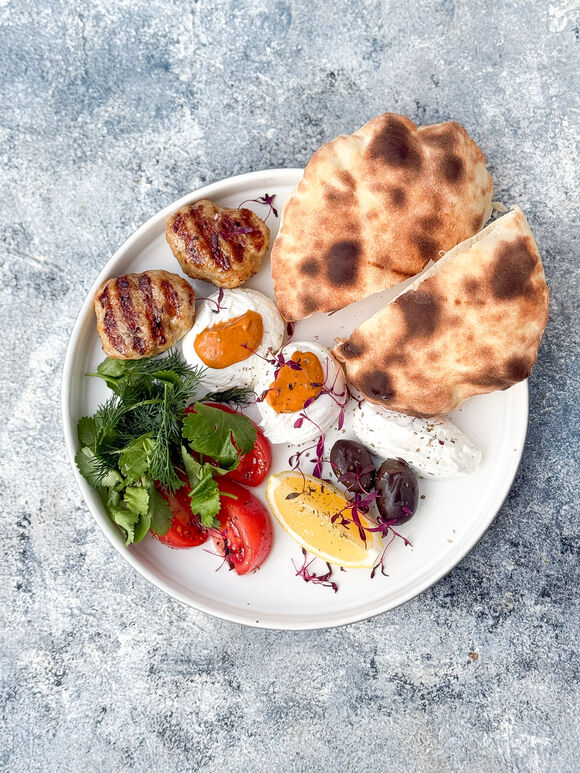 <p>Восточный завтрак с яйцом пашот , соусом Ромеско, лепешкой куриными котлетками, томатами, зеленью, оливками и муссом Сиртаки</p>